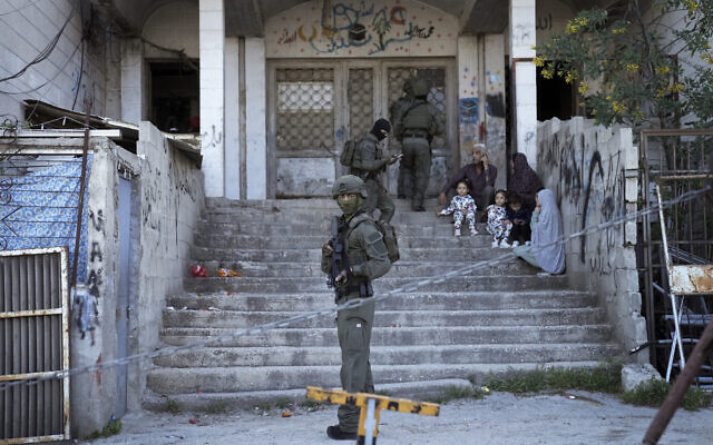 A Palestinian family waits outside their home as Israeli security forces search for suspects following a shooting attack in the neighborhood of Sheikh Jarrah in East Jerusalem, April 18, 2023. (AP Photo/Mahmoud Illean) A Palestinian family waits outside their home as Israeli security forces search for suspects following a shooting attack in the neighborhood of Sheikh Jarrah in East Jerusalem, April 18, 2023. (AP Photo/Mahmoud Illean)