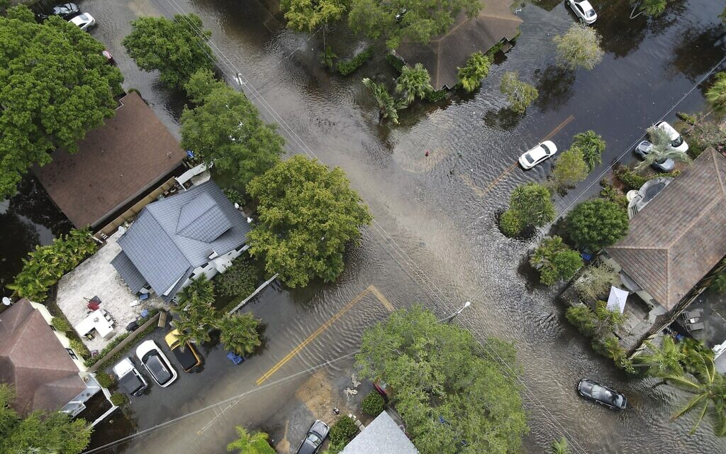 A pair of waterlogged cars sit abandoned in the road as floodwaters recede in the Sailboat Bend neighborhood of Fort Lauderdale, Fla., Thursday, April 13, 2023. Over 25 inches of rain fell in South Florida since Monday, causing widespread flooding. (AP/Rebecca Blackwell)