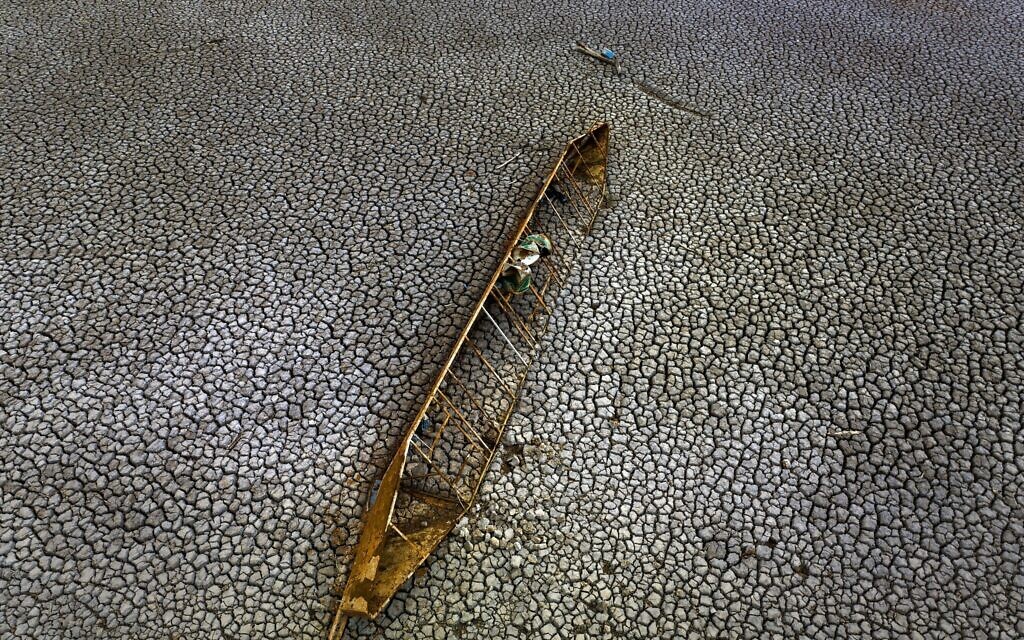 An old boat is photographed half-buried after the water level has dropped at the Sau reservoir, about 100 km (62 miles) north of Barcelona, Spain, Tuesday, April 18, 2023. (AP/Emilio Morenatti)