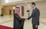 In this photo released by the Syrian official news agency SANA, Syrian President Bashar Assad, right, welcomes Saudi Minister of Foreign Affairs Faisal bin Farhan, left, before their meeting in Damascus, Syria, April 18, 2023. (SANA via AP)