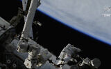 In this photo provided by NASA, astronaut Steve Bowen and United Arab Emirates astronaut Sultan Alneyadi  route power cables to prepare for future power system upgrades outside the International Space Station, on April 28, 2023. (NASA via AP)