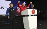 Turkey's President Recep Tayyip Erdogan (center) holds up the hands of Turkish air force pilot Alper Gezeravci (left) and aviation systems engineer Tuva Cihangir Atasever at Teknofest military fair, in Istanbul, Turkey, April 29, 2023. (Turkish Presidency via AP)
