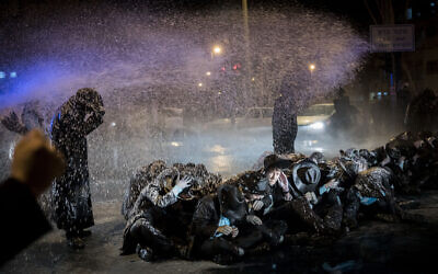 File: Police use a water cannon to disperse a protest against the arrest of a yeshiva student who failed to comply with an IDF conscription order, at the entrance to Jerusalem, on March 23, 2017. (Yonatan Sindel/Flash90)
