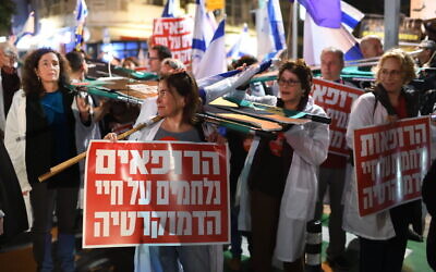 Israeli doctors carrying 'Doctors Fighting for Democracy' attend a rally against the government's judicial overhaul bills, Tel Aviv, February 25, 2023. (Gili Yaari /Flash90) Israeli doctors carrying 'Doctors Fighting for Democracy' attend a rally against the government's judicial overhaul bills, Tel Aviv, February 25, 2023. (Gili Yaari /Flash90)