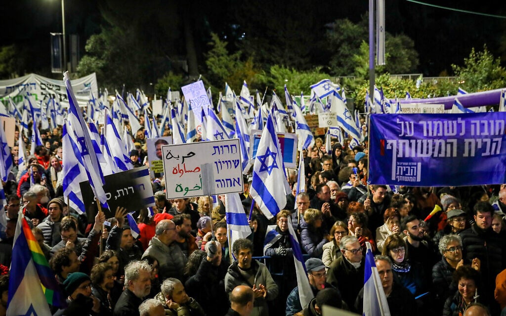 Israelis protest against the government's planned judicial overhaul, outside the President's Residence in Jerusalem, on April 1, 2023. The banner at right reads: "It's vital to safeguard the common home"; the banner at center reads: "Freedom, equality, kinship." (Noam Revkin Fenton/Flash90) Israelis protest against the government's planned judicial overhaul, outside the President's Residence in Jerusalem, on April 1, 2023. The banner at right reads: "It's vital to safeguard the common home"; the banner at center reads: "Freedom, equality, kinship." (Noam Revkin Fenton/Flash90)