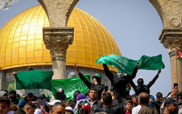 Palestinians wave flags after Friday prayers at the Al Aqsa Mosque Compound in Jerusalem's Old City, April 7, 2023. (Jamal Awad/Flash90)