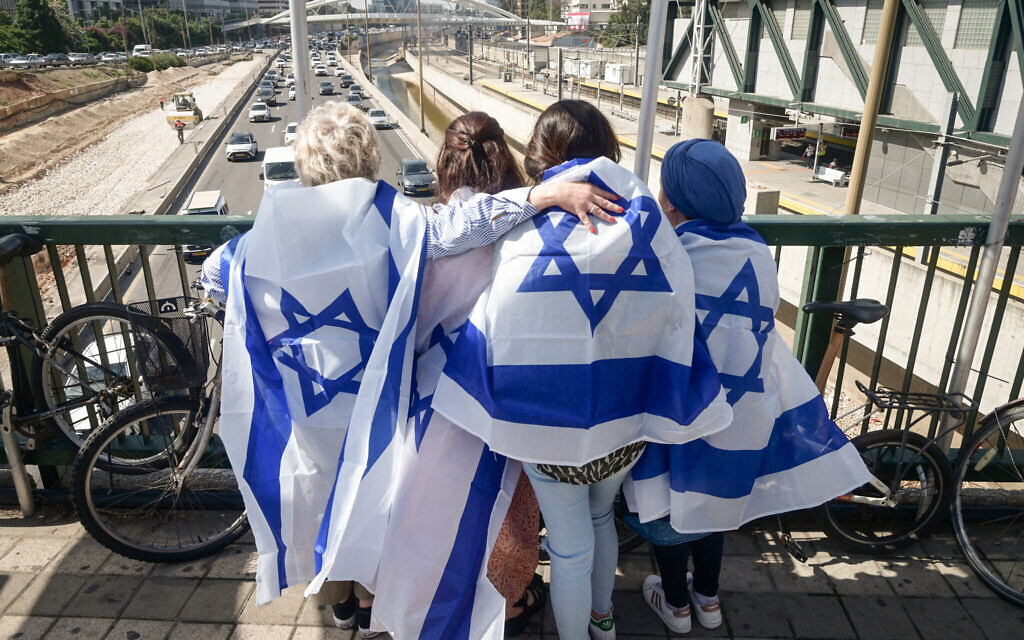 People stand still near the Ayalon highway in Tel Aviv as a two-minute siren is sounded across Israel to mark Holocaust Remembrance Day on April 18, 2023. (Avshalom Sassoni/Flash90)