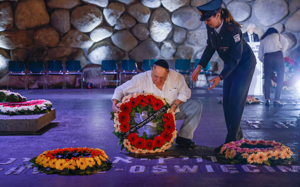 Holocaust survivors and their relatives and friends lay wreaths on names of concentration camps on the floor of the Hall of Remembrance at the Yad Vashem holocaust museum in Jerusalem, on Holocaust Remembrance Day on April 18, 2023. (Erik Marmor/Flash90)