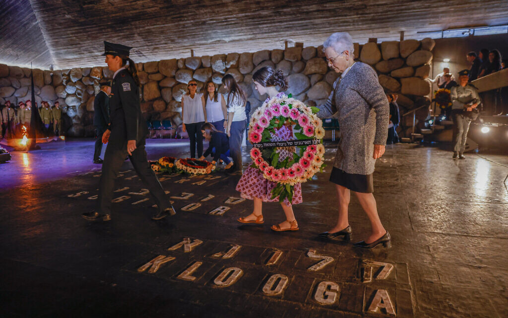 Holocaust survivors and their relatives and friends lay wreaths on names of concentration camps on the floor of the Hall of Remembrance at the Yad Vashem holocaust museum in Jerusalem, on Holocaust Remembrance Day on April 18, 2023. (Erik Marmor/Flash90)