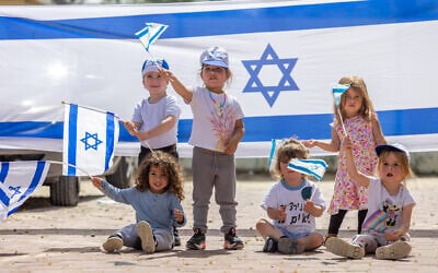 Children play with Israeli flags ahead of Israel's 75th Independence Day in Moshav Yashresh, on April 19, 2023 (Yossi Aloni/Flash90) Children play with Israeli flags ahead of Israel's 75th Independence Day in Moshav Yashresh, on April 19, 2023 (Yossi Aloni/Flash90)