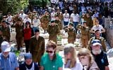 Israelis stand in silence next to graves of soldiers at the Mount Herzl miitary cemetery in Jerusalem during the Memorial Day siren, April 25, 2023. (Erik Marmor/Flash90)