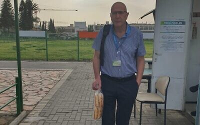 Gal Ifergane, the director of the neurology department, poses outside Soroka Medical Center in Beersheba with rolls he brought in to protest a ban on such products in hospitals during the Passover holiday. (Gal Ifergane, via Facebook)