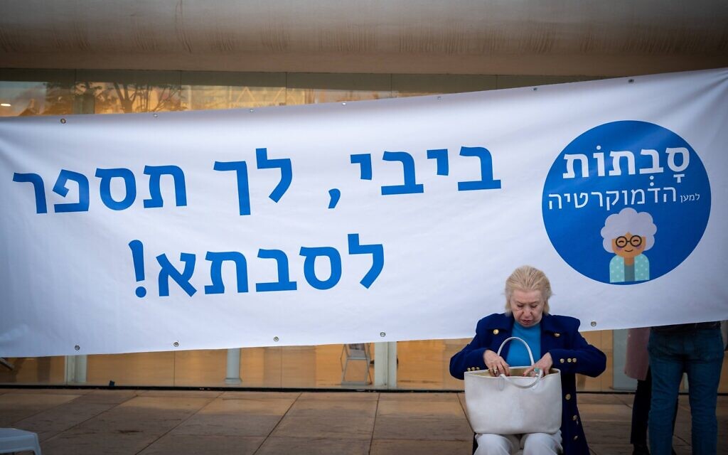 A woman takes part in a grandmothers' protest in Tel Aviv against the government's judicial overhaul plan, April 20, 2023. The banner reads, "Bibi, go tell it to your grandma." (Stav Tzur)