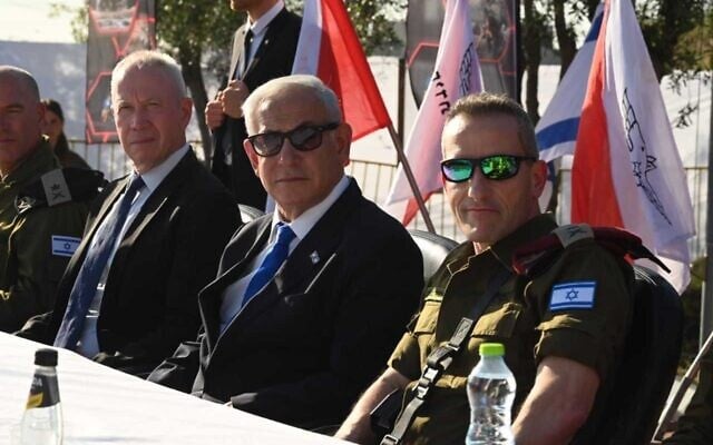 Yoav Gallant, left, and Benjamin Netanyahu, center, at an army ceremony on April 3, 2023. (Ariel Hermoni/Defense Ministry)