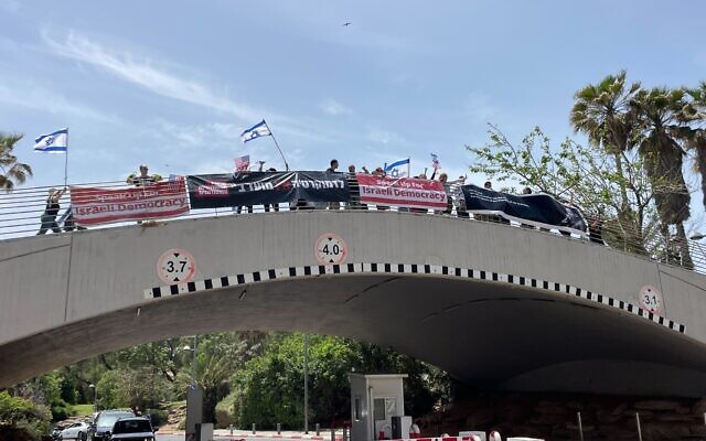 Anti-overhaul protesters outside Hilton Hotel in Tel Aviv, as coalition lawmakers are set to address a conference inside. (Carrie Keller-Lynn/Times of Israel)