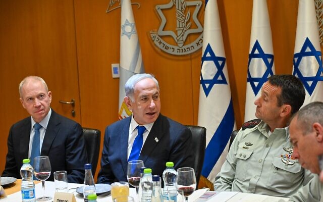Defense Minister Yoav Gallant (left), Prime Minister Benjamin Netanyahu (center) and IDF chief Herzi Halevi at a pre-Passover toast at the Defense Ministry on April 4, 2023. (Kobi Gideon/GPO)