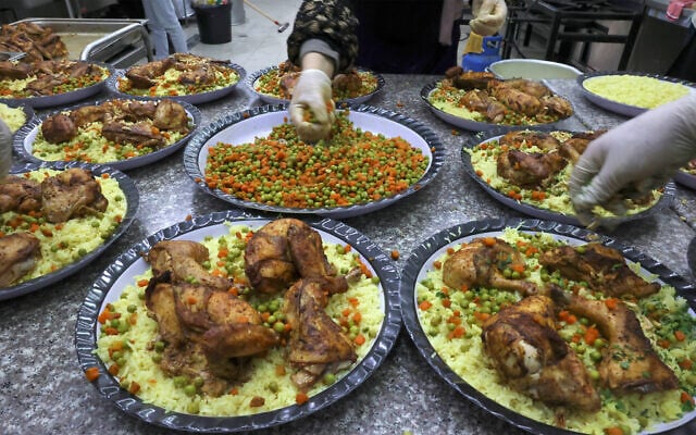 Illustrative: Cooks employed by the Islamic Charitable Society prepare portions of the daily 'iftar' (fast breaking) meal for Palestinian orphans and families in need, in the West Bank city of Hebron, during the Muslim holy month of Ramadan, on April 12, 2022. (Hazem Bader/AFP) Illustrative: Cooks employed by the Islamic Charitable Society prepare portions of the daily 'iftar' (fast breaking) meal for Palestinian orphans and families in need, in the West Bank city of Hebron, during the Muslim holy month of Ramadan, on April 12, 2022. (Hazem Bader/AFP)