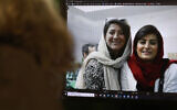 A woman looks at a picture of Iranian reporters Niloufar Hamedi and Elahe Mohammadi posted on Twitter, in Nicosia on November 2, 2022. (Christina Assi/AFP)