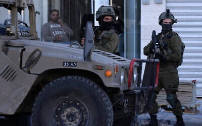 File: Israeli soldiers stand guard at the Jit junction, west of Nablus, in the northern West Bank, after three Palestinian gunmen were killed during a shootout, on March 12, 2023. (Jaafar Ashtiyeh / AFP)
