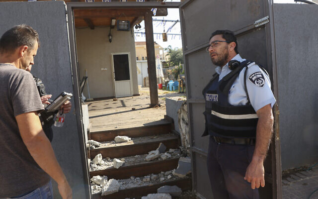 Israeli security forces and emergency personnel inspect a damaged house in the southern city of Sderot following rocket fire from Gaza on May 2, 2023 (GIL COHEN-MAGEN/AFP)