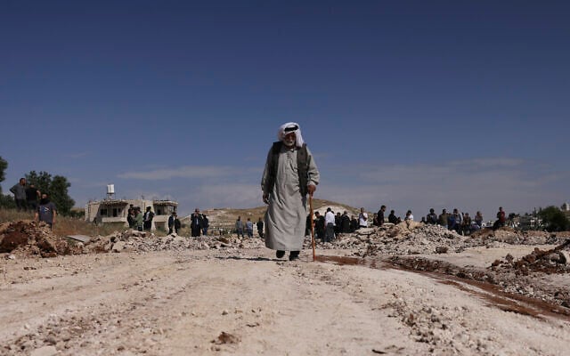 An elderly Palestinian man walks away from a crowd as military bulldozers demolish a school that Israel says was built without permission, in the village of Jabbet al-Dhib, east of Bethlehem in the West Bank, on May 7, 2023. (Hazem Bader/AFP) An elderly Palestinian man walks away from a crowd as military bulldozers demolish a school that Israel says was built without permission, in the village of Jabbet al-Dhib, east of Bethlehem in the West Bank, on May 7, 2023. (Hazem Bader/AFP)