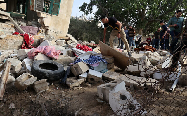 People assess the damage of the house of  the deputy commander of a rocket launch unit killed by Israel on May 11, 2023. (Photo by SAID KHATIB / AFP)