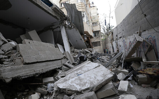 People walk amidst the debris of a building hit by an Israeli air strike after rocket fire, in Gaza City on May 13, 2023 (MAHMUD HAMS / AFP) People walk amidst the debris of a building hit by an Israeli air strike after rocket fire, in Gaza City on May 13, 2023 (MAHMUD HAMS / AFP)