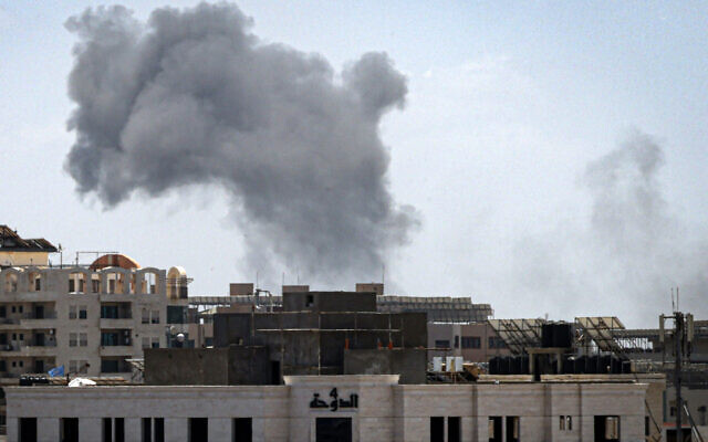 A plume of smoke rises above a building after an Israeli airstrike in Gaza City on May 13, 2023, amid fighting between Israel and Palestinian Islamic Jihad. (Mahmud Hams/AFP)