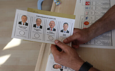 A person holds a ballot at a polling station for parliamentary and presidential elections in Ankara, Turkey, on May 14, 2023. (Adem ALTAN / AFP)