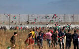 Palestinian flags are fixed to Israel's security barrier during a demonstration along the border with Israel east of Gaza City on May 18, 2023. (Mohammed ABED / AFP)