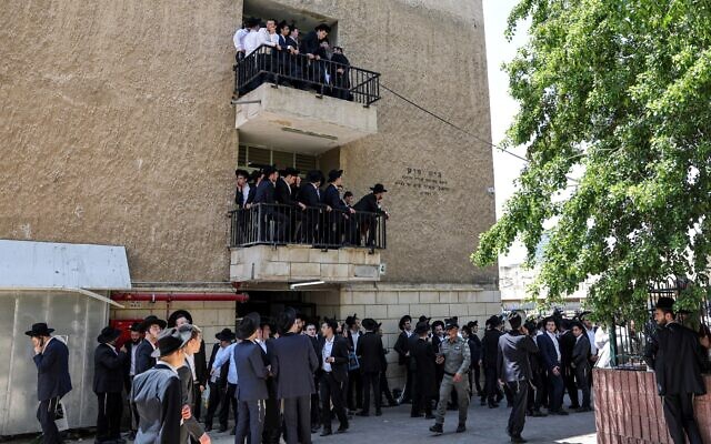 Mourners watch from balconies as they gather for the funeral of Rabbi Gershon Edelstein near the Ponevezh Yeshiva in Bnei Brak on May 30, 2023. (JACK GUEZ / AFP)