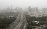 Illustrative: A view shows the skyline of Tel Aviv covered by a cloud of dust, on March 23, 2021. (Jack Guez/AFP)