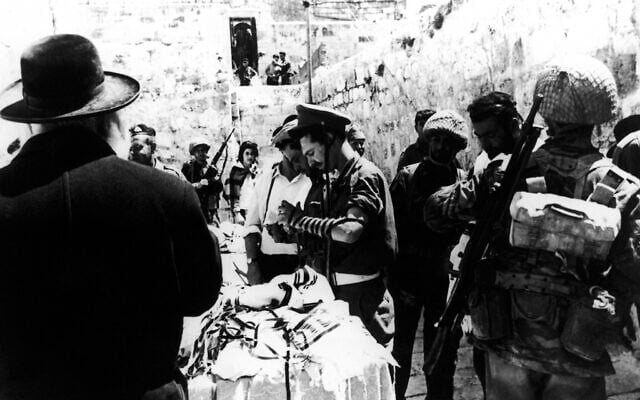 In this June 8, 1967 file photo a man lends prayer shawls and phylacteries to Israeli soldiers praying at the Western Wall in the Old City of Jerusalem, one day after its capture from the Jordanians during the Six-Day War. (AP Photo, File) In this June 8, 1967 file photo a man lends prayer shawls and phylacteries to Israeli soldiers praying at the Western Wall in the Old City of Jerusalem, one day after its capture from the Jordanians during the Six-Day War. (AP Photo, File)