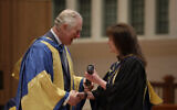 Britain's Prince Charles shakes hands as he presents British composer for film and television Debbie Wiseman with an honorary Fellowship award at the Royal College of Music's annual awards in London, Tuesday, March 3, 2020. (AP Photo/Matt Dunham, Pool)