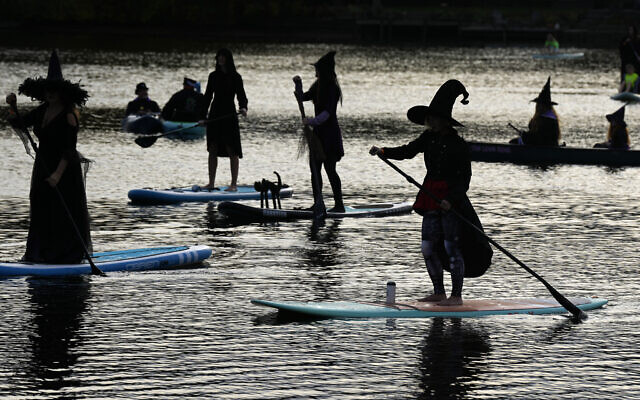 Illustrative: Participants dressed as witches ride paddleboards during the Medford Lakes Lions Witches Paddle Halloween event on October 22, 2022, in Medford Lakes, New Jersey. (Photo by Charles Sykes/Invision/AP) Illustrative: Participants dressed as witches ride paddleboards during the Medford Lakes Lions Witches Paddle Halloween event on October 22, 2022, in Medford Lakes, New Jersey. (Photo by Charles Sykes/Invision/AP)