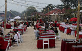 Tourists sit at a restaurant on Jimbaran Beach in Bali, Indonesia on November 12, 2022. (AP Photo/Firdia Lisnawati)