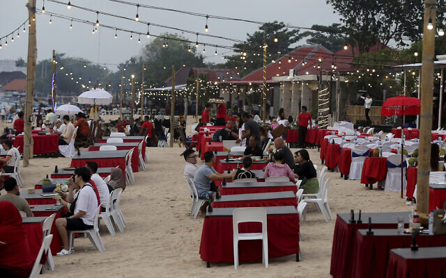 Tourists sit at a restaurant on Jimbaran Beach in Bali, Indonesia on November 12, 2022. (AP Photo/Firdia Lisnawati) Tourists sit at a restaurant on Jimbaran Beach in Bali, Indonesia on November 12, 2022. (AP Photo/Firdia Lisnawati)