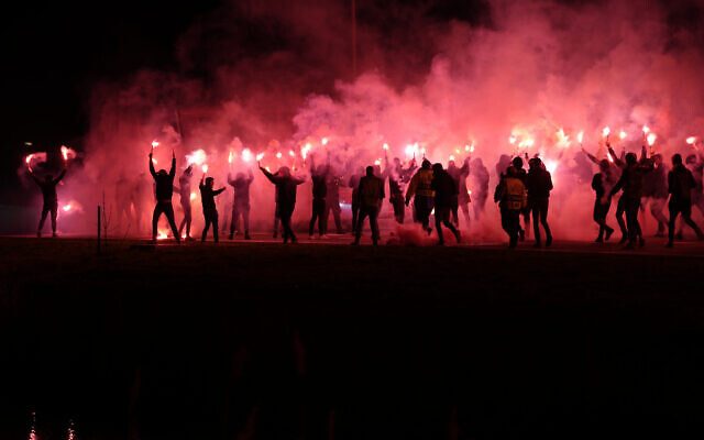 Illustrative: Supporters of Dutch soccer team AZ Alkmaar, some holding flares, run to meet the players' bus before the round of 16, second leg, Conference League soccer match between AZ and Lazio at the AZ stadium in Alkmaar, Netherlands, March 16, 2023. (AP Photo/Peter Dejong) Illustrative: Supporters of Dutch soccer team AZ Alkmaar, some holding flares, run to meet the players' bus before the round of 16, second leg, Conference League soccer match between AZ and Lazio at the AZ stadium in Alkmaar, Netherlands, March 16, 2023. (AP Photo/Peter Dejong)
