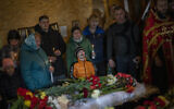 Mykhayl Shulha, center, cries next to the coffin of his sister Sofia Shulha during a funeral prayer in Uman, central Ukraine, April 30, 2023. (AP Photo/Bernat Armangue)