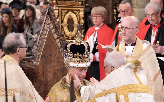 King Charles III sits as he is crowned with St Edward's Crown by The Archbishop of Canterbury the Most Reverend Justin Welby during the coronation ceremony at Westminster Abbey, London, Saturday, May 6, 2023. (Jonathan Brady/Pool Photo via AP)