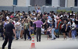 People gather across the street from a US shopping center after a shooting on May 6, 2023, in Allen, Texas. (AP Photo/LM Otero)