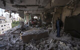 A Palestinian man inspects damage to his building following Israeli airstrikes on an apartment of an Islamic Jihad commander in Gaza City, May 9, 2023. (AP Photo/Fatima Shbair)