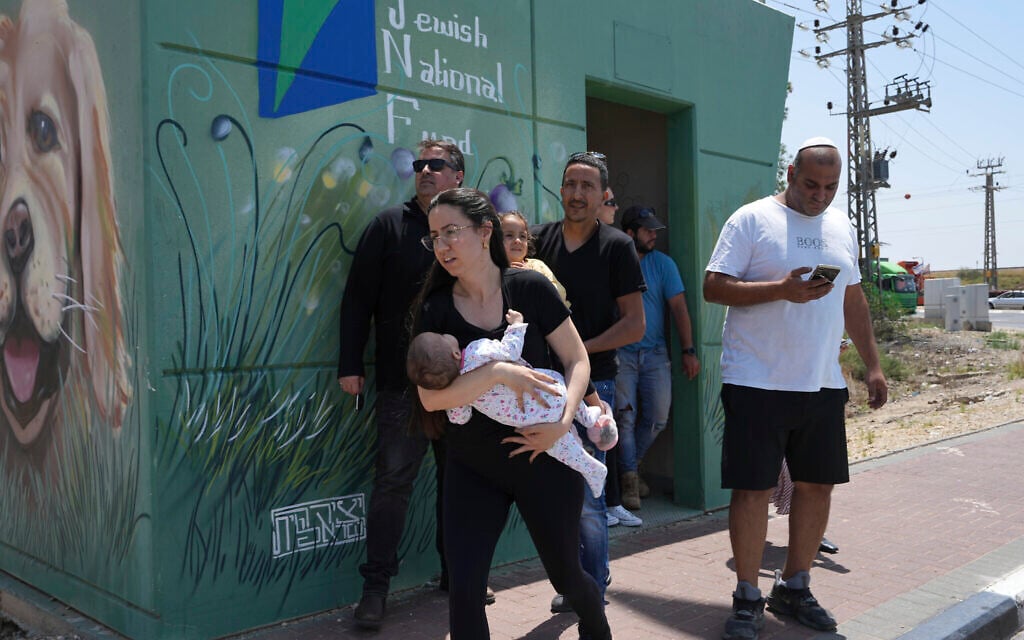 People leave a shelter in between air raid sirens warning of incoming rockets fired from the Gaza Strip, in Sderot, southern Israel, near the Gaza border, May 10, 2023. (AP Photo/Tsafrir Abayov)