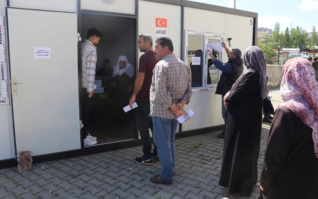 People wait outside containers to vote in Turkey's general election in earthquake-hit Malatya, Turkey, May 14, 2023. (IHA via AP) People wait outside containers to vote in Turkey's general election in earthquake-hit Malatya, Turkey, May 14, 2023. (IHA via AP)