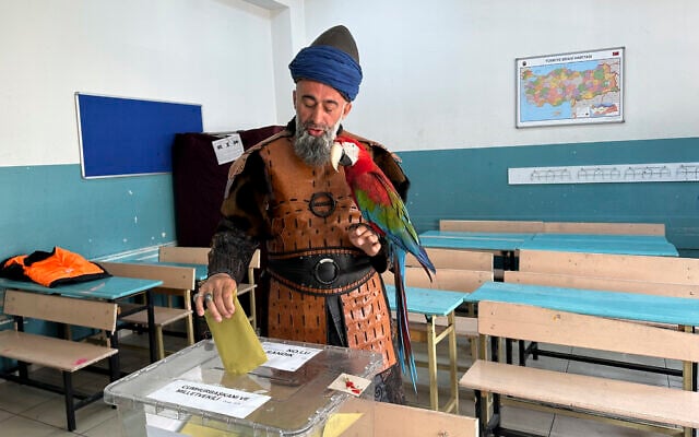 Nazim Cihan, 48, holds his bird as he votes in Turkey's general election in Istanbul, May 14, 2023. (IHA via AP) Nazim Cihan, 48, holds his bird as he votes in Turkey's general election in Istanbul, May 14, 2023. (IHA via AP)