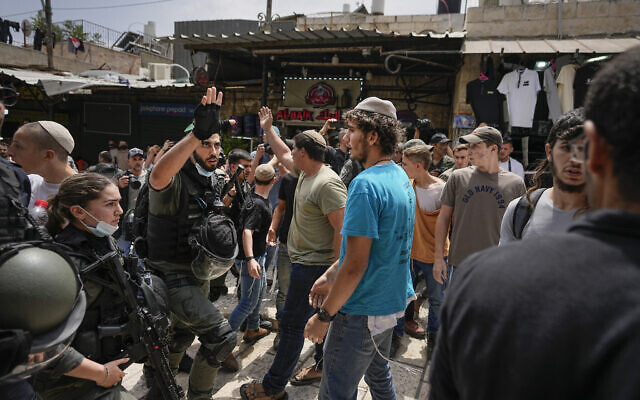 Police officers separate Israelis and Palestinians during a march marking Jerusalem Day, in front of the Damascus Gate of Jerusalem's Old City, May 18, 2023. (AP Photo/Ohad Zwigenberg) Police officers separate Israelis and Palestinians during a march marking Jerusalem Day, in front of the Damascus Gate of Jerusalem's Old City, May 18, 2023. (AP Photo/Ohad Zwigenberg)