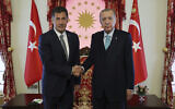 In this photo released by Turkish Presidency, Turkish President and People's Alliance's presidential candidate Recep Tayyip Erdogan, right, shakes hands with Sinan Ogan, former presidential candidate from ATA alliance, in Istanbul, Turkey, on May 19, 2023. (Turkish Presidency via AP, File)