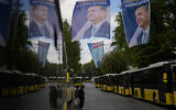 Commuters wait for buses next to election banners of Turkish President and People's Alliance's presidential candidate Recep Tayyip Erdogan, top, and Turkish CHP party leader and Nation Alliance's presidential candidate Kemal Kilicdaroglu, background, in Istanbul, Turkey, Tuesday, May 23, 2023. (AP/Francisco Seco)