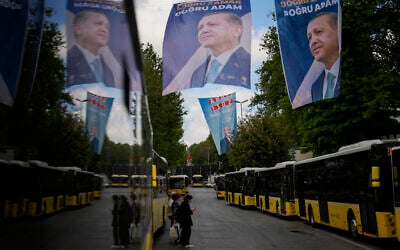 Commuters wait for buses next to election banners of Turkish President and People's Alliance's presidential candidate Recep Tayyip Erdogan, top, and Turkish CHP party leader and Nation Alliance's presidential candidate Kemal Kilicdaroglu, background, in Istanbul, Turkey, Tuesday, May 23, 2023. (AP/Francisco Seco)