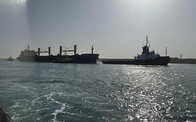 Bulk carrier ship Xin Hai Tong 23, left, is towed after it ran aground at the southern mouth of the Suez Canal in Egypt, May 25, 2023. (Suez Canal Authority via AP)